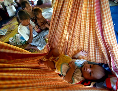 A baby rests comfortably in a hammock