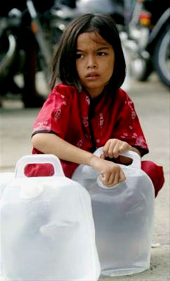 A young girl clings to the family's drinking water