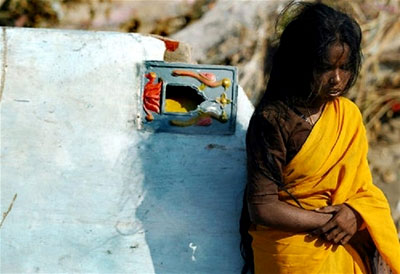 An intropective young girl stands amid the destruction
in southern India