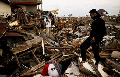 Men search for survivors amid the rubble of Banda Aceh, Indonesia