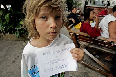 A young boy holds up a sign that reads: 