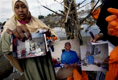 A woman shows a picture of her missing family members