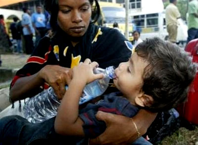A mother gives water to her son