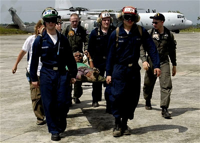 U.S. Navy personnel tranport an injured man
