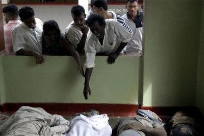 A man reaches down to touch a dead family member