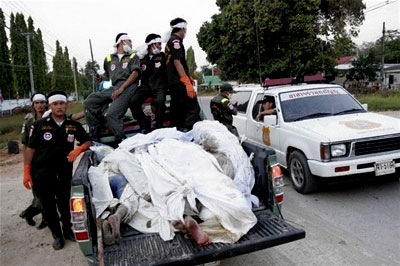 Workers move the dead to the morgue