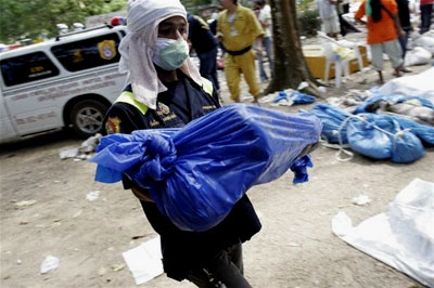 A worker carries a dead child