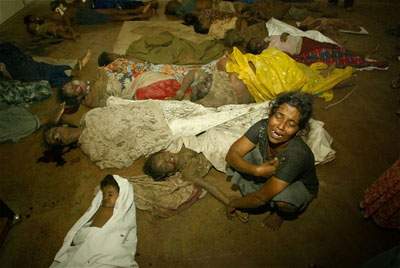 A woman screams and cries as she touches the hand of her dead child