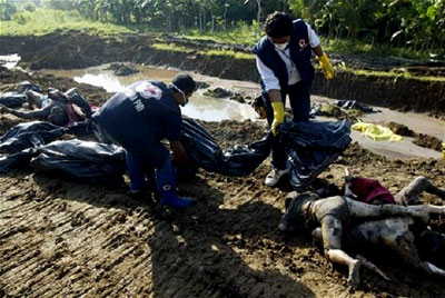 Workers wrap the dead