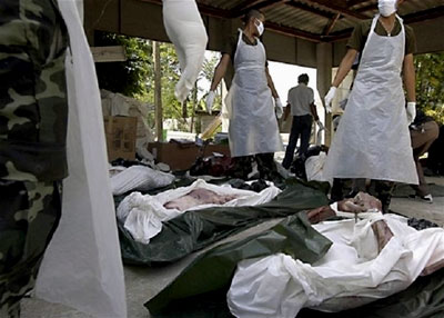 Workers wrap the dead