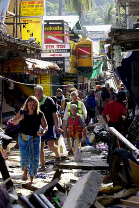 Tourists walk through rubble in Thailand.