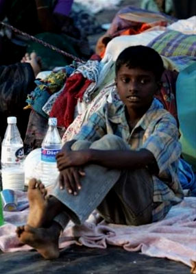 A boy rests after receiveing his water