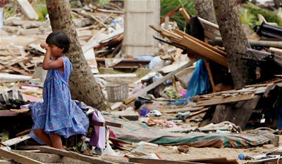 A young girl cries as she views her family's destroyed home